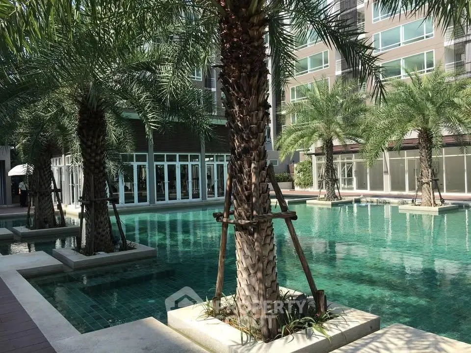 Luxurious apartment complex with stunning pool and palm trees, perfect for relaxation and leisure.