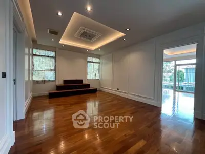 Spacious empty living room with hardwood floors and recessed lighting