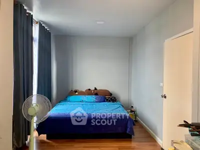 Cozy bedroom with blue bedding and wooden flooring, perfect for relaxation.