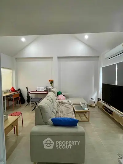 Spacious living room with modern decor and large TV setup, perfect for entertainment.