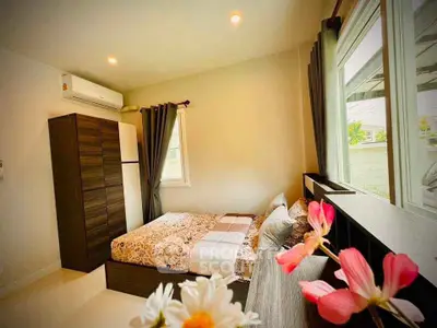 Cozy bedroom with large window and modern decor, featuring a comfortable bed and ample storage space.
