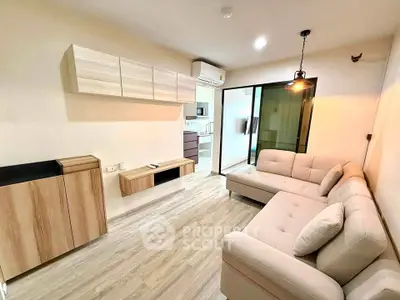 Modern living room with cozy beige sofa and stylish wooden cabinets, open layout leading to kitchen.