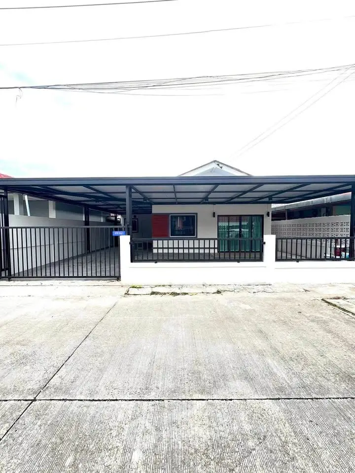 Modern single-story house with covered parking and sleek metal gate