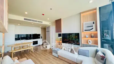 Modern living room with open kitchen, stylish decor, and natural light