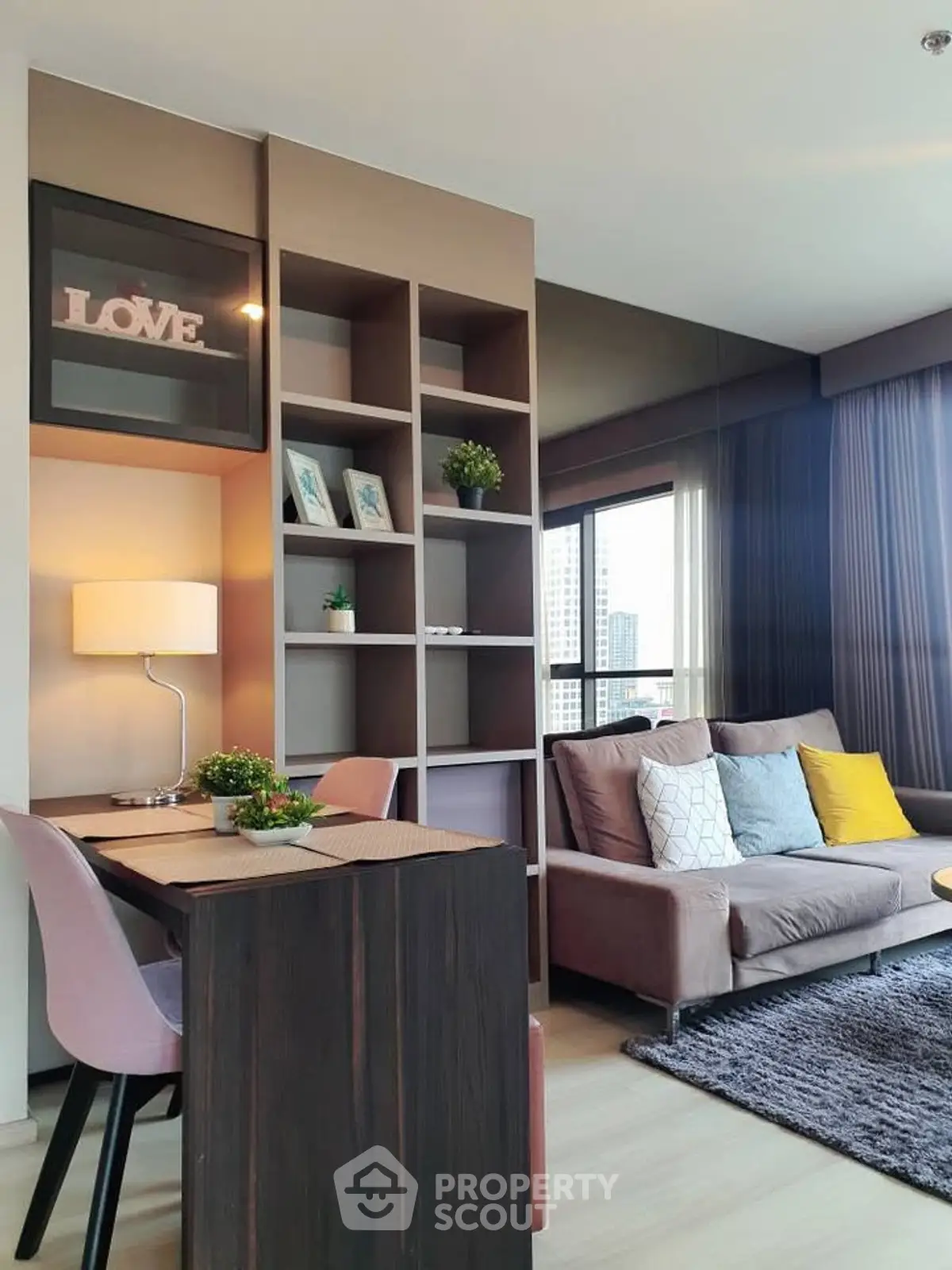 Modern living room with stylish decor and city view, featuring cozy seating and elegant shelving.
