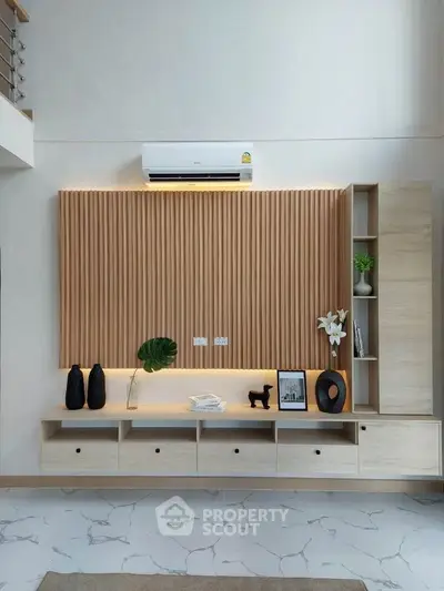 Modern living room with stylish wooden paneling and sleek storage solutions.