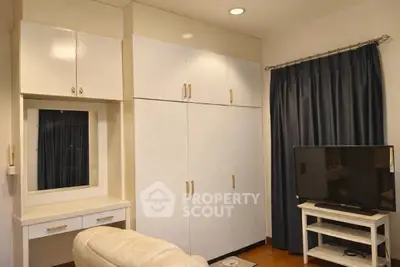 Cozy living room with built-in wardrobe and TV setup, perfect for relaxation.