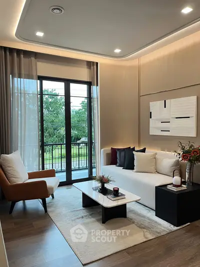 Modern living room with elegant decor and large windows opening to a balcony view.