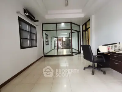 Spacious office space with glass partition and modern furnishings