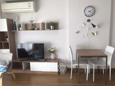 Modern living room with stylish decor, TV unit, and dining area in a cozy apartment.