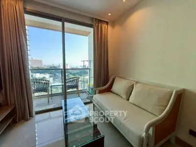 Charming living room with cozy sofa and glass coffee table, leading to a balcony with a stunning city view.