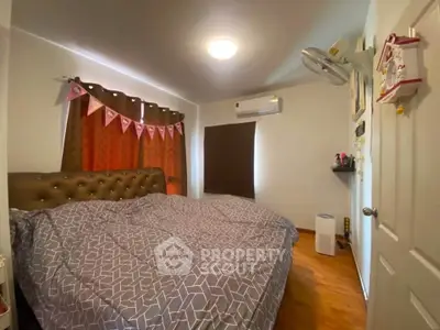 Cozy bedroom with modern decor and ample natural light, featuring a stylish bed and air conditioning.