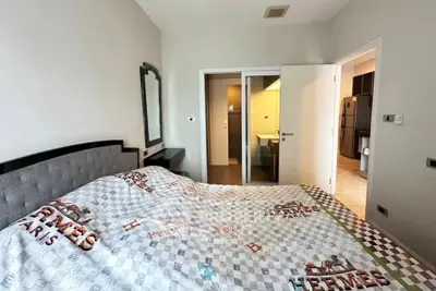Spacious bedroom with modern decor and ensuite bathroom in luxury apartment.