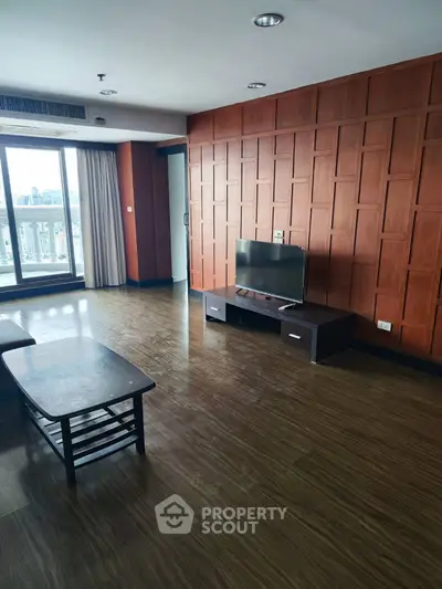 Spacious living room with wooden paneling and city view, perfect for modern living.