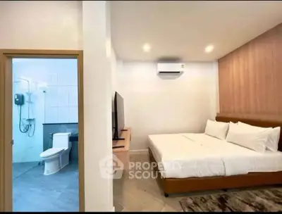 Modern bedroom with ensuite bathroom, featuring sleek design and cozy ambiance.