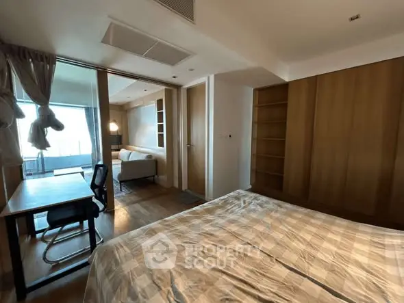 Spacious bedroom with study area and balcony view in modern apartment.