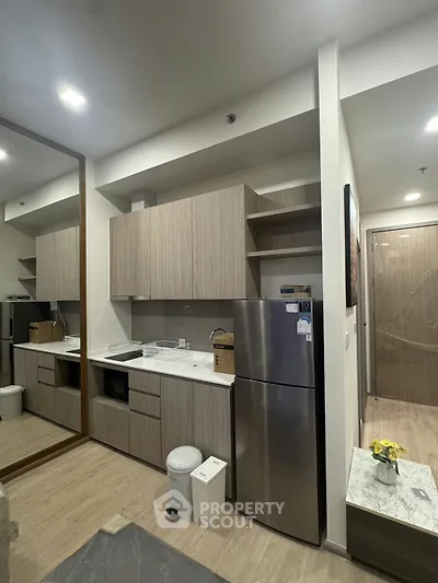 Modern kitchen with sleek cabinetry and stainless steel appliances in a contemporary apartment.