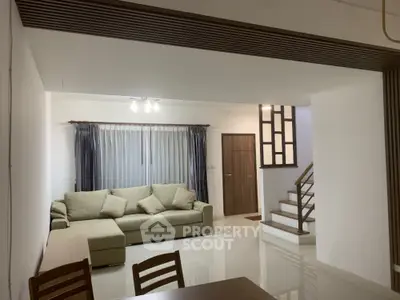 Spacious living room with modern sofa and elegant staircase in a stylish home