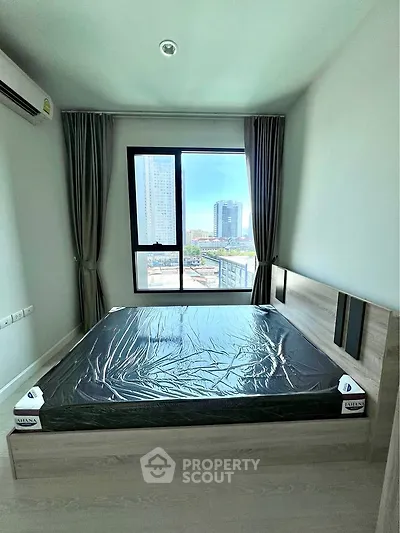 Modern bedroom with large window offering city view, featuring sleek bed and minimalist decor.