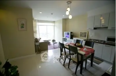Modern open-layout living room and kitchen with dining area and natural light.
