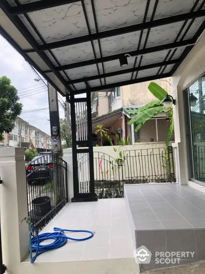 Charming residential entrance with modern covered patio and garden view