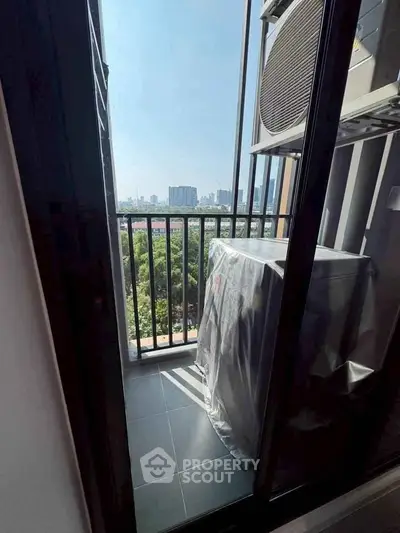 Compact balcony with city view and air conditioning unit, ideal for urban living.