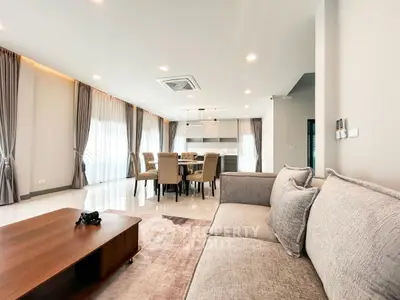 Spacious modern living room with elegant dining area and natural light.