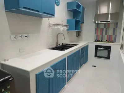 Modern kitchen with blue cabinets, gas stove, and sleek design