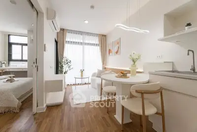 Modern open-plan living room and kitchen with stylish decor and natural light.