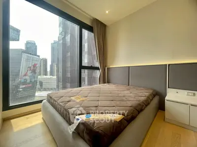 Modern bedroom with city view in high-rise apartment, featuring sleek design and large window.