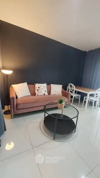 Modern living room with stylish sofa and dining area, featuring elegant decor and cozy ambiance.