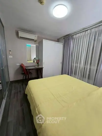 Cozy bedroom with modern decor, featuring a comfortable bed, stylish wardrobe, and a compact study area.