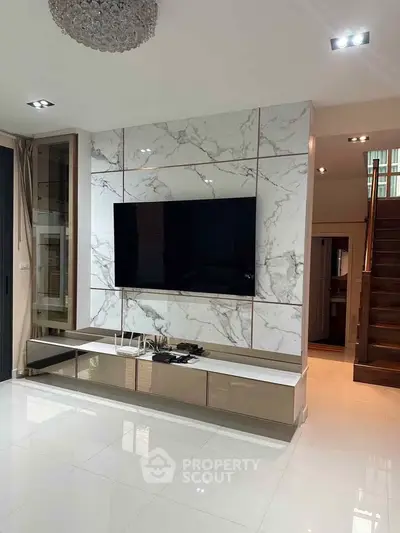Luxurious living room with marble accent wall and modern TV setup