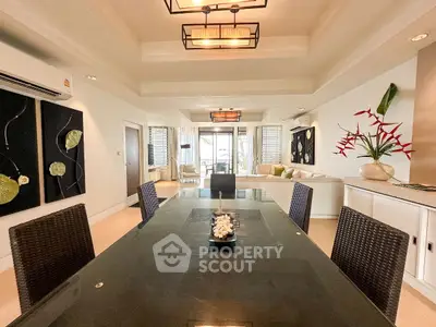 Luxurious open-plan living and dining area with modern decor and elegant lighting.