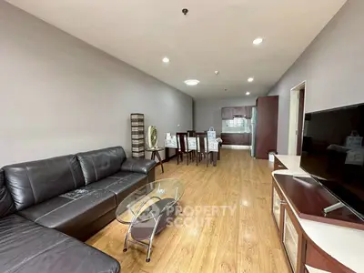 Spacious living room with modern furniture and open kitchen layout.
