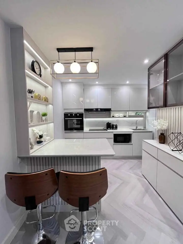 Modern kitchen with sleek design, featuring an open layout and stylish bar seating.