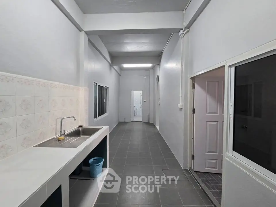 Spacious minimalist kitchen with sleek countertops and ample storage space.