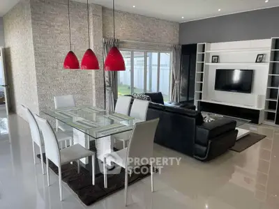 Modern living room with sleek furniture and stylish dining area, featuring red pendant lights and a large TV unit.