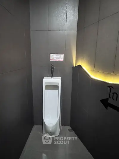 Modern public restroom with sleek urinal and ambient lighting