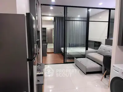 Modern studio apartment with glass partition, sleek furniture, and polished flooring.