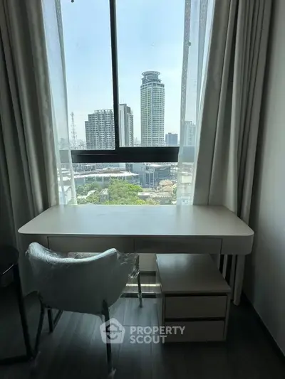 Modern study area with city view, featuring sleek desk and chair by large window.