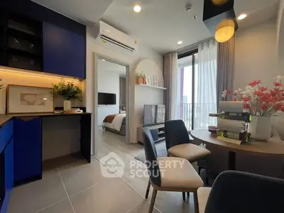Modern open-plan living room with dining area and balcony view in stylish apartment.