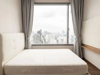 Spacious bedroom with city view and large window in modern apartment