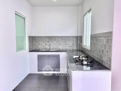 Modern kitchen with sleek design, featuring a gas stove and stylish gray cabinetry.