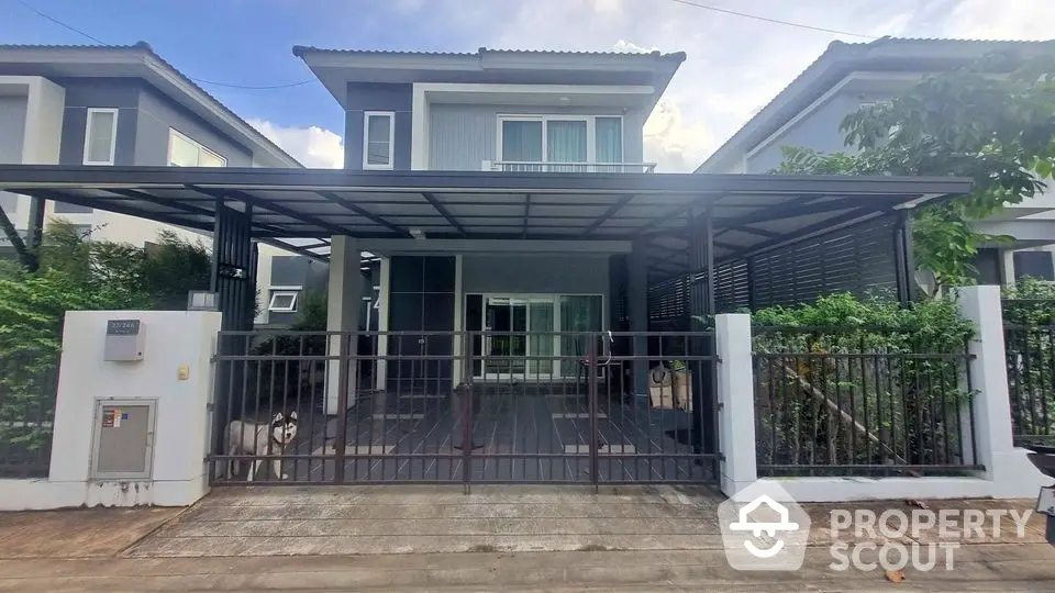 Modern two-story house with gated entrance and spacious driveway