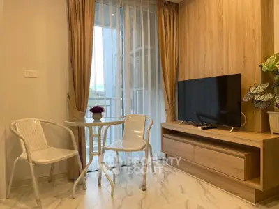 Modern living room with TV and balcony view, featuring stylish furniture and elegant decor.