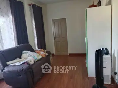 Cozy living room with plush sofa and wooden flooring, perfect for relaxation.