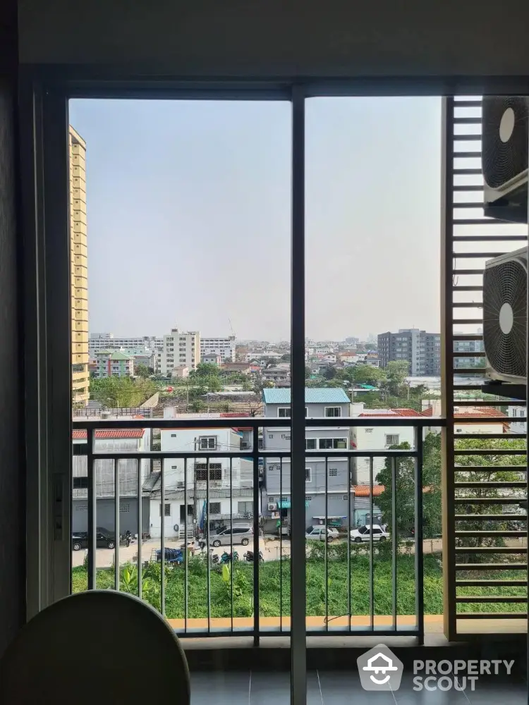 Stunning cityscape view from modern apartment balcony with sleek railing design.