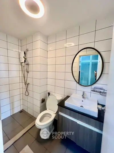 Modern bathroom with sleek fixtures and stylish round mirror