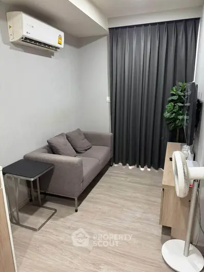 Cozy living room with modern sofa, air conditioning, and sleek decor, perfect for relaxation and comfort.